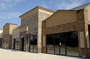 A row of empty storefronts in a modern strip mall with brick and stucco facades, large windows, and no signs or businesses visible—offering the perfect blank canvas for exterior siding upgrades or a comprehensive remodeling service. A row of empty storefronts in a modern strip mall with brick and stucco facades, large windows, and no signs or businesses visible—offering the perfect blank canvas for exterior siding upgrades or a comprehensive remodeling service.