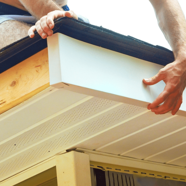 A person performs soffit installation and adjusts a white fascia board on the edge of a house roof, ensuring a clean finish—ideal for homes in Salt Lake City. A person performs soffit installation and adjusts a white fascia board on the edge of a house roof, ensuring a clean finish—ideal for homes in Salt Lake City.