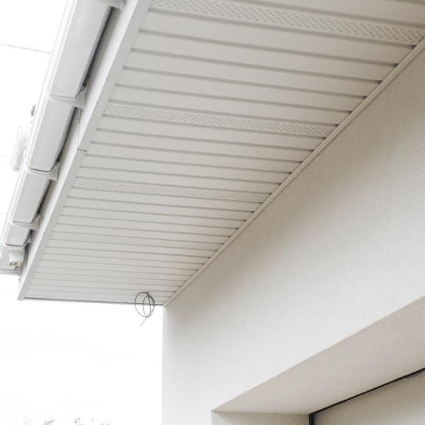 Close-up view of a building’s soffit with white paneling and a green wire protruding near the edge of the roof, showcasing expert soffit installation in Salt Lake City. Close-up view of a building’s soffit with white paneling and a green wire protruding near the edge of the roof, showcasing expert soffit installation in Salt Lake City.
