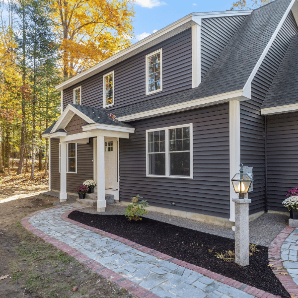Happy Utah Homeowners After Exterior Siding Renovation Happy family standing in front of newly remodeled home exterior with fresh siding
