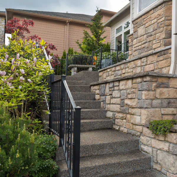 Happy Homeowners After Exterior Stone Veneer Remodel Happy homeowners standing in front of their newly renovated stone veneer exterior